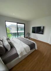 Modern bedroom with large window and wall-mounted TV