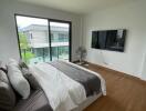 Modern bedroom with large window and wall-mounted TV