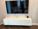 Modern living room corner with wall-mounted TV and floating cabinet