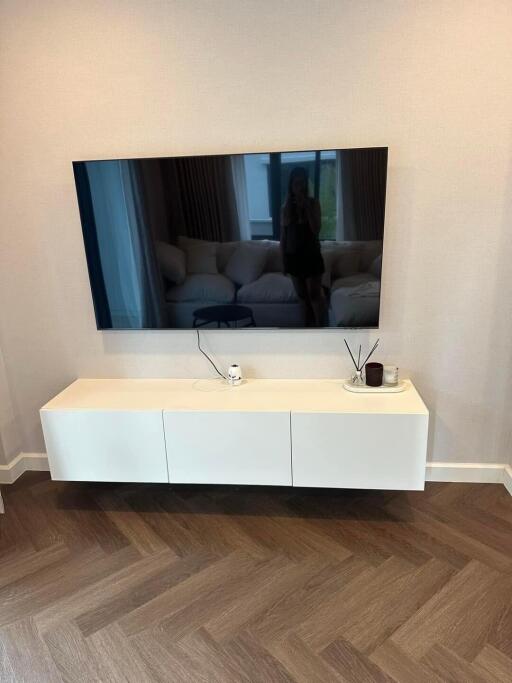 Modern living room corner with wall-mounted TV and floating cabinet