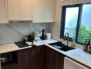 A modern kitchen with white cabinets and marble backsplash