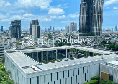 Aerial view of a modern cityscape with high-rise buildings and lush greenery.