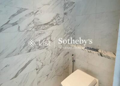 Modern bathroom with marble walls and a sleek toilet