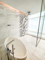 Modern bathroom with marble tiles and a freestanding bathtub