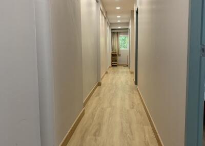 Long hallway with wooden floors and white walls