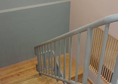 Staircase with wooden steps and light-colored railing