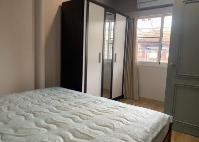 Bedroom with bed, wardrobe, window and air conditioning unit