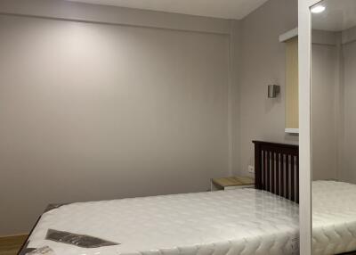 minimalist bedroom with single bed and neutral wall color