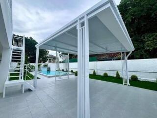 Modern outdoor patio with stairs leading to raised platform, overlooking a swimming pool