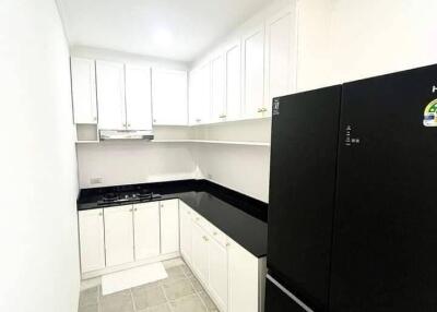 Modern white kitchen with black appliances and countertops