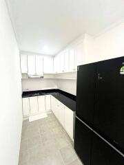 Modern white kitchen with black appliances and countertops