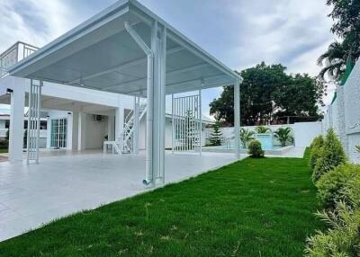 Well-maintained backyard with a pergola and green lawn