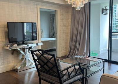 Modern living room with elegant chandelier and glass doors to balcony