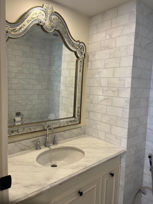 Elegant bathroom with a framed mirror and marble countertop