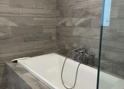 Modern bathroom with bathtub and tiled walls