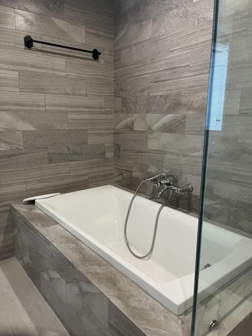 Modern bathroom with bathtub and tiled walls