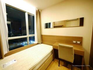 Bedroom with window, bed, and desk.