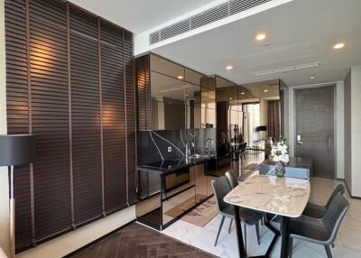 Modern living room and dining area with wooden flooring and large mirrors