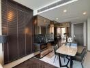 Modern living room and dining area with wooden flooring and large mirrors