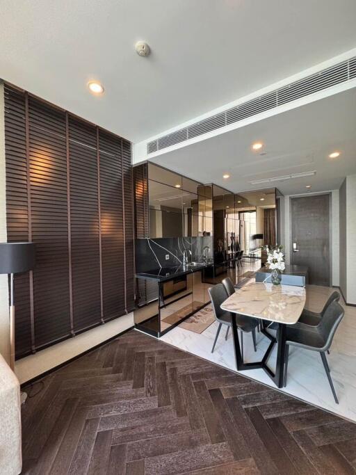 Modern living room and dining area with wooden flooring and large mirrors