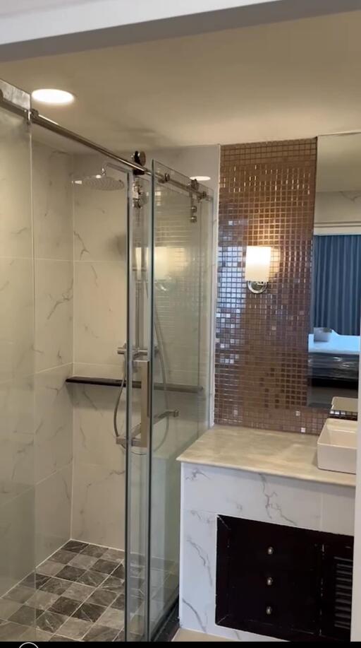 Modern bathroom with glass-walled shower and marble countertops