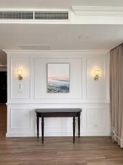 Elegant wall paneling with wall sconces and a decorative console table beneath a framed artwork