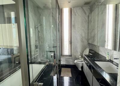 Modern bathroom with glass shower, bathtub, vanity, and toilet