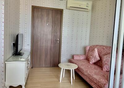 Cozy living room with air conditioner, sofa, TV, and a coffee table