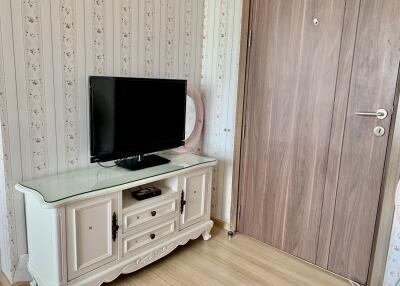 Living room with TV and wooden entry door