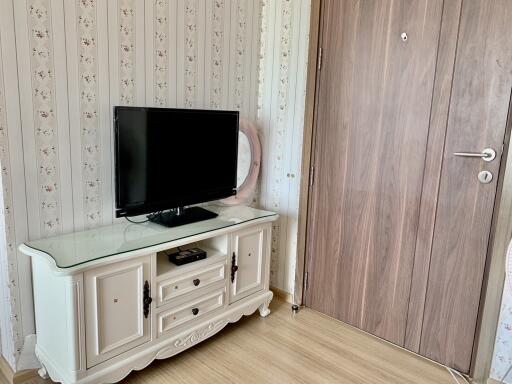 Living room with TV and wooden entry door