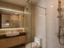 Modern bathroom with glass shower, toilet, and vanity