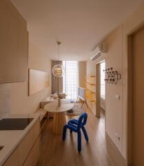 Modern living area with dining table, unique blue chair, and open plan layout