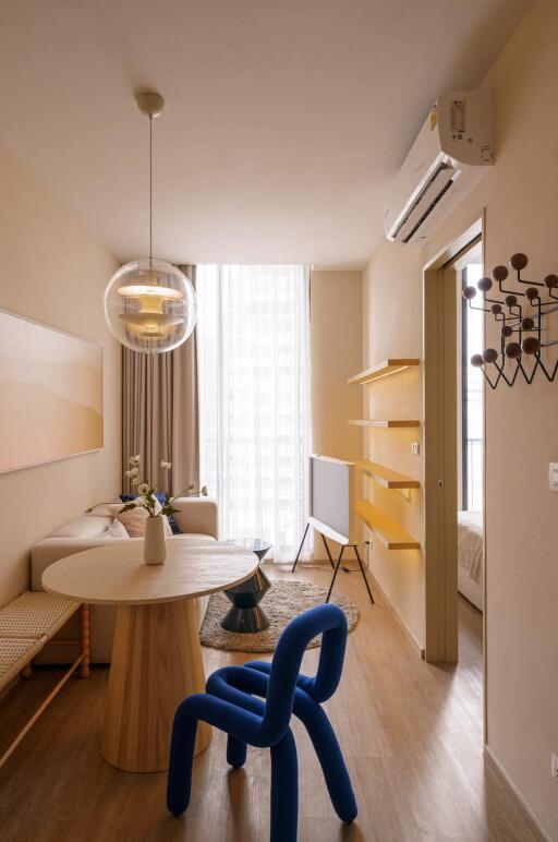 Modern living room with dining area, blue chair, and wall-mounted TV