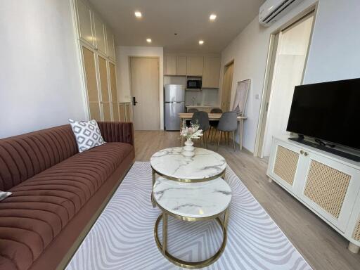 Stylish living room with kitchen, featuring modern furniture and appliances.