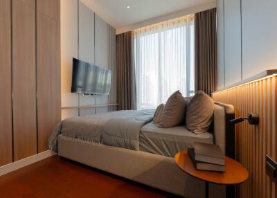 Modern bedroom with bed, TV, and curtains