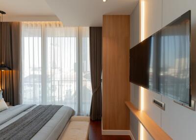 Modern bedroom with large TV and natural light