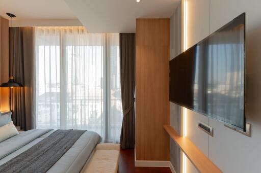 Modern bedroom with large TV and natural light