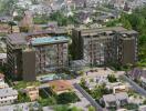 Aerial view of modern residential complex with swimming pool and surrounding neighborhood