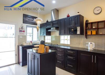 Modern kitchen with dark cabinets and central island