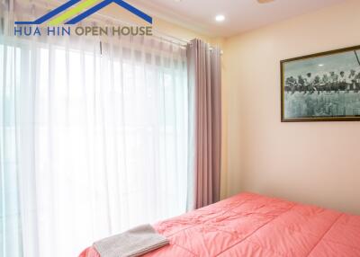 Bedroom with large window and pink bedding