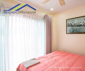 Bedroom with large window and pink bedding