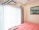 Bedroom with large window and pink bedding