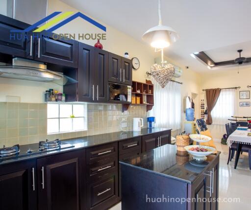 Modern kitchen featuring dark wood cabinets and a kitchen island