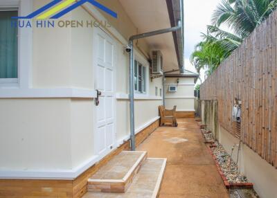 Side of the building with a pathway and outdoor seating area