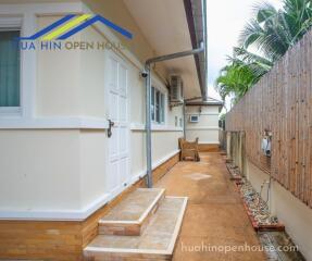 Side of the building with a pathway and outdoor seating area