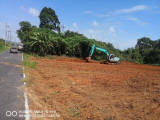 Plot of land with excavator and greenery