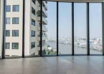 Spacious living area with large windows offering a river and city view