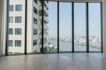 Spacious living area with large windows offering a river and city view