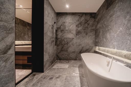 Modern bathroom with marble tiles and a freestanding bathtub