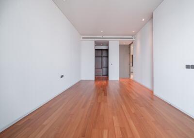 Spacious empty bedroom with wooden flooring and built-in wardrobe